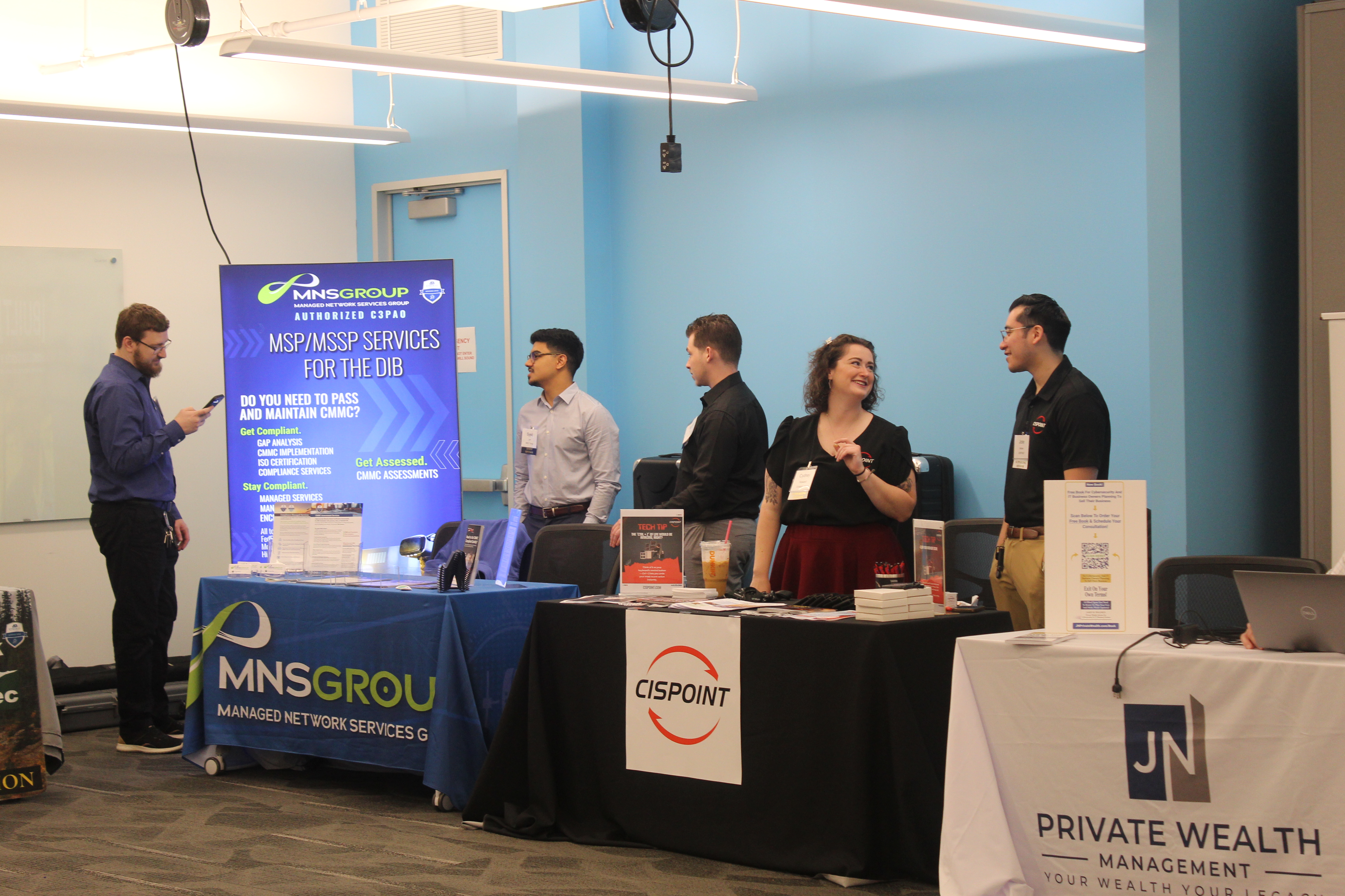 Cybersecurity professionals and government contractors networking at the 2025 CMMC Summit, discussing CMMC 2.0 compliance, assessment readiness, and controlled unclassified information (CUI) protection.