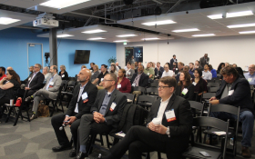 Cybersecurity professionals and government contractors networking at the 2025 CMMC Summit, discussing CMMC 2.0 compliance, assessment readiness, and controlled unclassified information (CUI) protection.